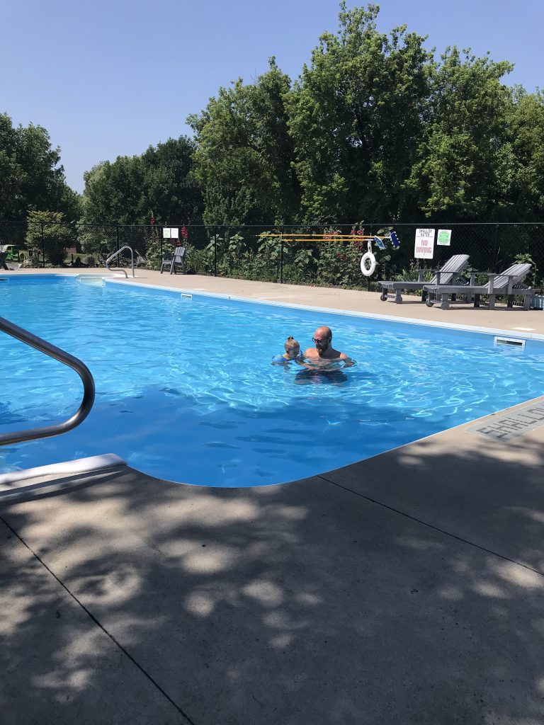 Guests swimming and relaxing by the heated pool at Southview Cottages.