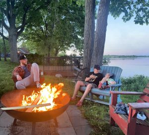 Family enjoying sunset on Rice Lake by bon fire.